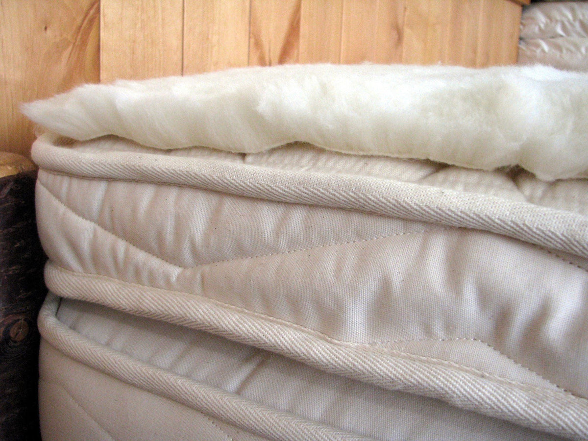 Happy Lamb Fleece Wool Topper on a bed