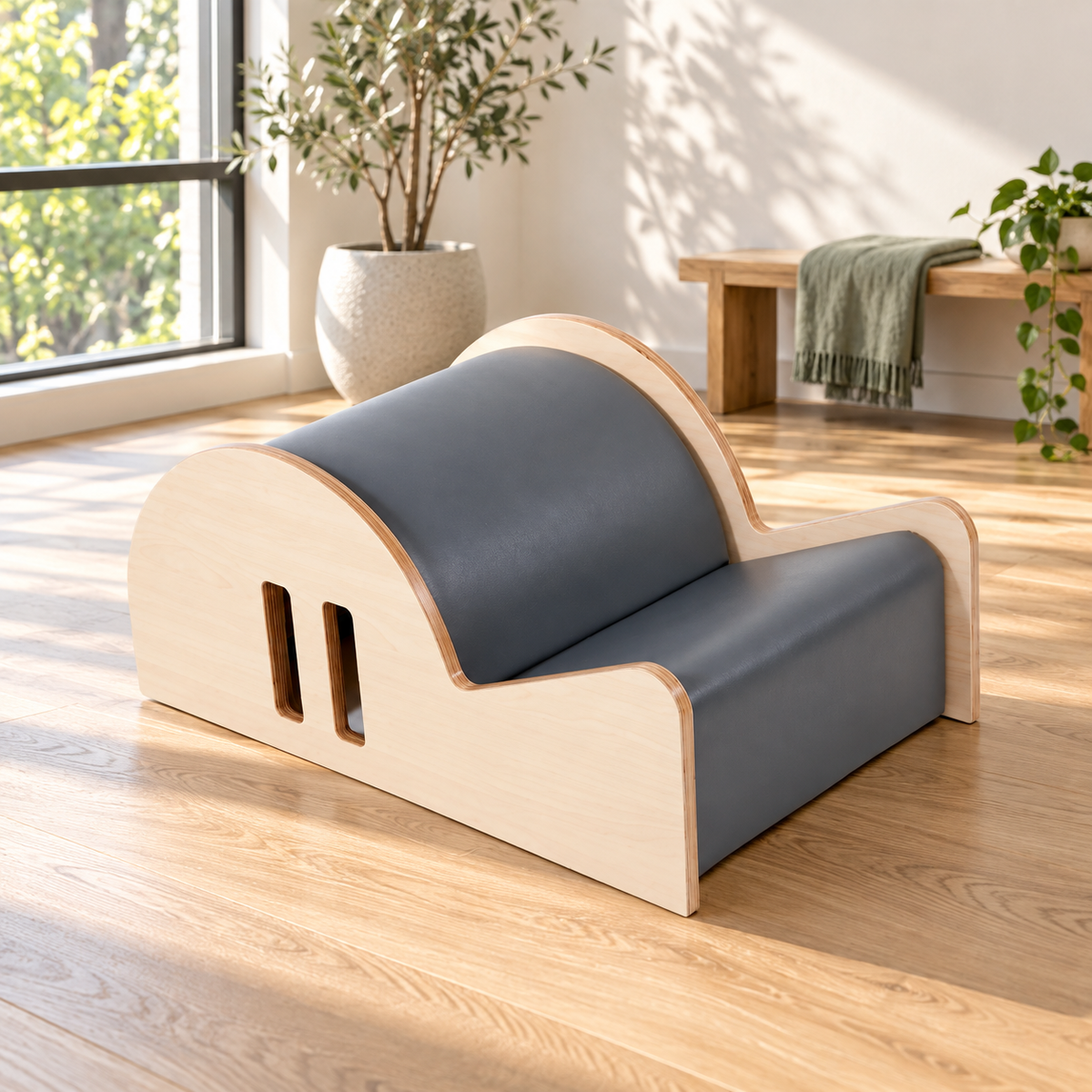 Elina Pilates Spine Corrector Elite in grey on an oak floor in a bright Pilates studio