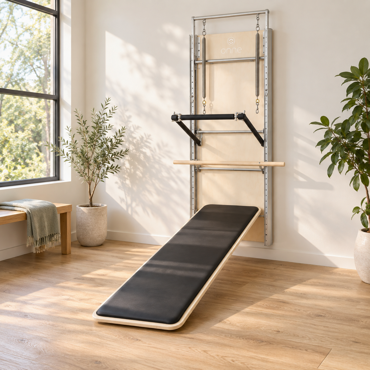 Elina Pilates Wall Board ONNE mounted on the wall of a bright Pilates studio with the mat board deployed