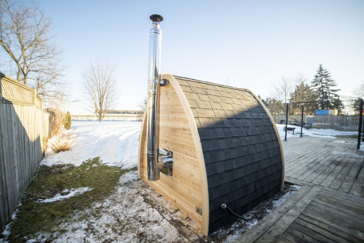 MiniPOD Sauna outdoors in winter, showing the full teardrop profile and cedar trim