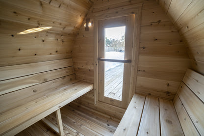 Inside the MiniPOD Sauna looking toward the glass door, showing the cedar benches on both sides