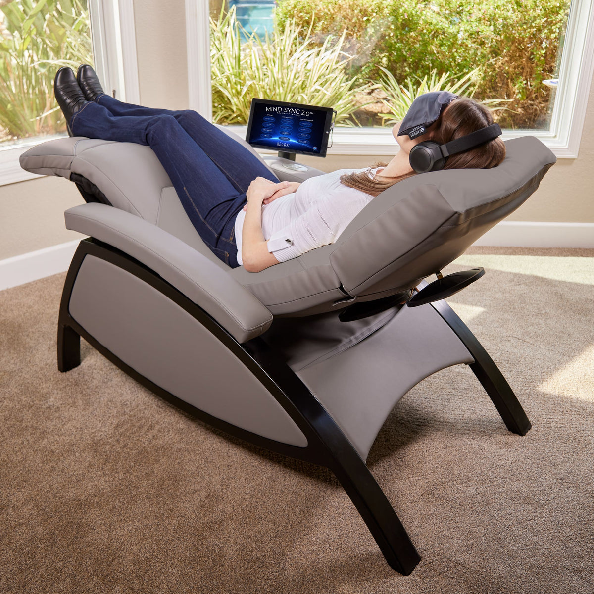 Woman relaxing on the Mind-Sync 2.0 lounger with headphones and eye mask
