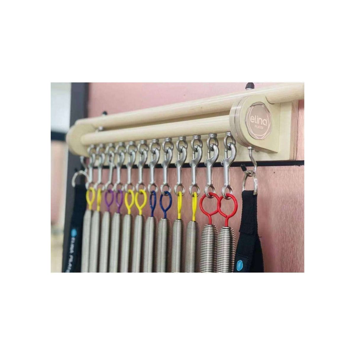 Elina Pilates Spring Hanger on a studio wall holding twelve springs and handles